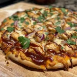 Primer plano de una pizza BBQ de pollo con mozzarella y salsa BBQ.