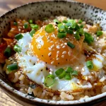 Tazón de arroz coreano con huevo frito y guarniciones.