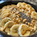 Tazón de avena nocturna con plátano y mantequilla de maní, mostrando ingredientes frescos.