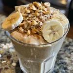 Batido de avena con mantequilla de maní en un vaso transparente.