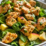 Vista lateral de ensalada con pollo, manzana y nueces.