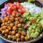 Tazón de arroz con garbanzos crujientes, lechuga, y verduras frescas.