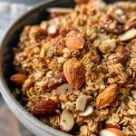 Granola con miel y almendras en un tazón, vista lateral.