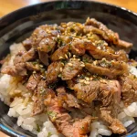 Tazón de Gyudon con carne de res y arroz, visto de lado.