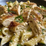 Plato delicioso de pasta corta con trozos de pollo y crema de ricotta en un fondo atractivo.