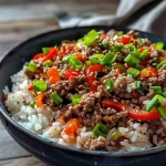 Tazón de arroz con carne de res y pimientos, visto de lado.