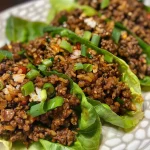 Rollo de lechuga con carne molida y arroz, en un fondo neutro.