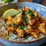 ['Bowl de arroz frito con pollo y salsa de mantequilla y limón.', 'Arroz basmati salteado con pechuga de pollo y salsa de limón.', 'Primer plano de un bowl de arroz frito con pollo.', 'Tazón de arroz frito con ingredientes frescos y coloridos.']