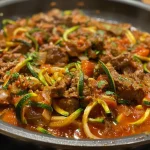 ['Cubos de carne de res jugosos acompañados de fideos de calabacín.', 'Vista lateral de steak en cubos con zoodles frescos.', 'Plato de carne de res con zoodles y tomates coloridos.', 'Detalle de carne cubo y fideos de calabacín servido en un plato.']