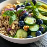 ['Ensalada de quinoa con arándanos y verduras frescas.', 'Primer plano de ensalada de quinoa con arándanos y aguacate.', 'Tazón de ensalada de quinoa con arándanos, espinacas y nueces.', 'Ensalada colorida de quinoa, arándanos y aderezo saludable.']