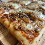 ['Pizza con queso de cabra y cebolla caramelizada en primer plano.', 'Vista lateral de una pizza deliciosa con ingredientes frescos.', 'Pizza horneada con cebolla caramelizada y queso de cabra.', 'Detalle de una pizza casera con queso de cabra fundido.']
