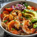 ['Bowl de quinoa con camarones, aguacate y tomates cherry.', 'Quinoa Bowl con gambas, decorado con cilantro fresco.', 'Tazón de quinoa con ingredientes frescos y colores vibrantes.', 'Vista lateral de un bowl de quinoa y camarones con vegetales.']