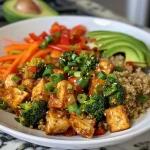['Tazón de quinoa colorido con tofu y verduras frescas.', 'Primer plano de un tazón de quinoa con tofu y vegetales.', 'Bowl saludable con quinoa, tofu y diversas verduras.', 'Tazón vibrante de quinoa y tofu acompañado de verduras.']