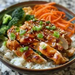 ['Tazón de arroz con pollo teriyaki acompañado de vegetales.', 'Primer plano de un bowl de pollo teriyaki con arroz y verduras.', 'Tazón de arroz con pollo teriyaki, brócoli y zanahorias.', 'Arroz con pollo teriyaki y aderezos en un plato atractivo.']