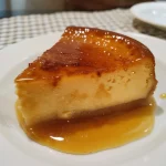 ['Flan de dulce de membrillo presentado en un plato.', 'Vista lateral de un flan de dulce de membrillo.', 'Flan de dulce de membrillo con caramelo líquido en la parte superior.', 'Detalle de un flan cremoso de dulce de membrillo.']