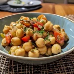 ['Plato de garbanzos con castañas presentado en un tazón.', 'Primer plano de garbanzos con castañas cocidos y sazonados.', 'Vista lateral de garbanzos con castañas dispuestos en un plato.', 'Receta de garbanzos con castañas en un plato atractivo.']