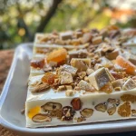 ['Nougat glacé servido en un plato, con frutas secas y confitadas.', 'Vista lateral de un nougat glacé decorado con frutos secos.', 'Primer plano de un delicioso nougat glacé con colores vibrantes.', 'Postre nougat glacé exhibido, mostrando su textura cremosa.']