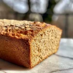 ['Pan de jengibre vegano con un aspecto jugoso y delicioso.', 'Vista lateral del pan de jengibre vegano recién horneado.', 'Pan de jengibre vegano, tierno y dorado, sobre una superficie de madera.', 'Close-up de pan de jengibre vegano mostrando su textura esponjosa.']