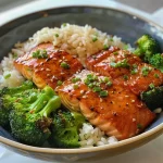 ['Tazón de salmón teriyaki con brócoli y arroz.', 'Placa lateral de salmón teriyaki con ingredientes frescos.', 'Primer plano de un tazón de salmón teriyaki y verduras.', 'Vista detallada de Teriyaki Salmon Bowls con salsa.']