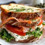 Sándwich club de salmón ahumado con ingredientes frescos.